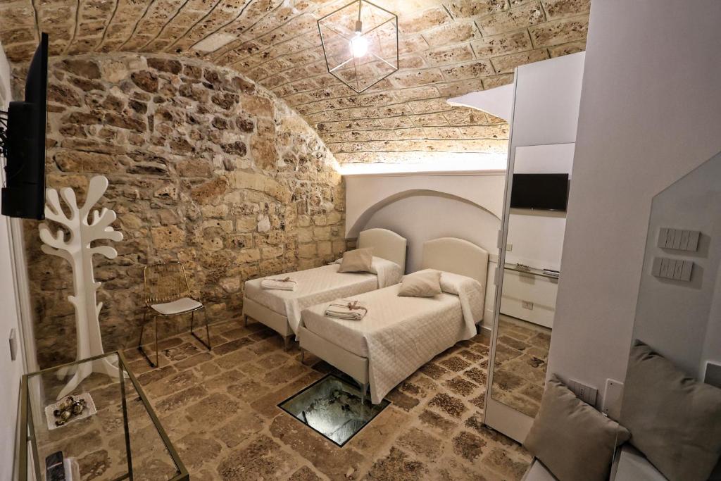 ein Schlafzimmer mit einem Bett und einer Steinmauer in der Unterkunft Dimora La Neviera in Altamura