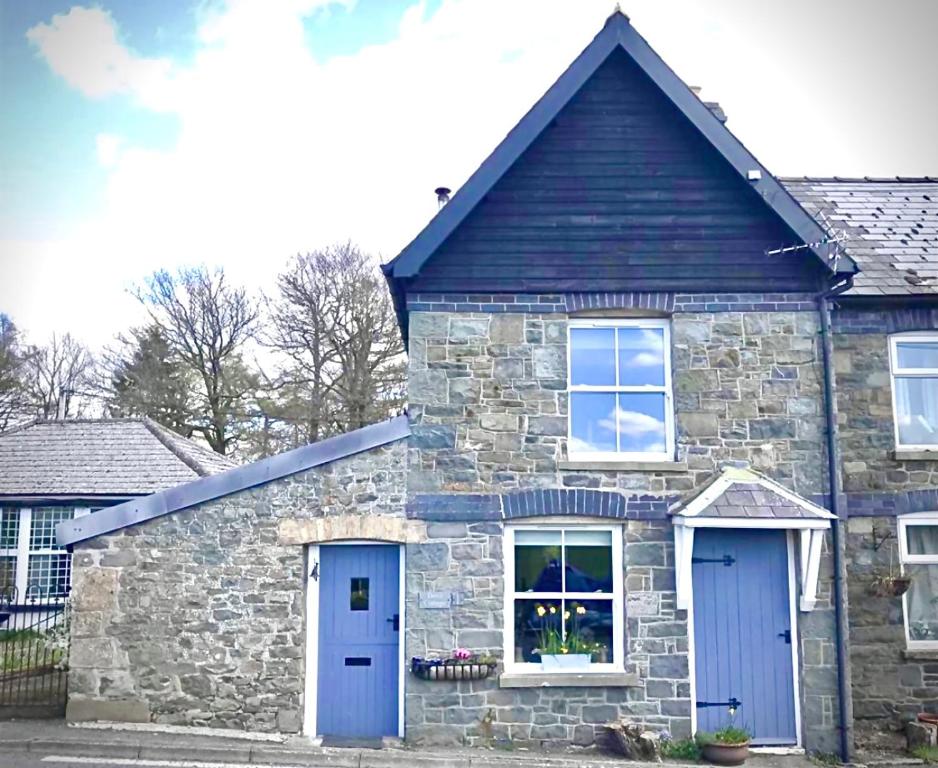 a stone house with blue doors and windows at Dove Cottage in Newbridge on Wye