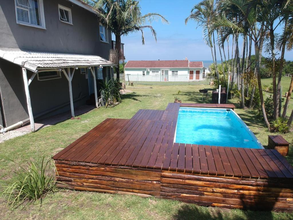 a pool with a wooden deck next to a house at Aqua on Newport street in Port Edward