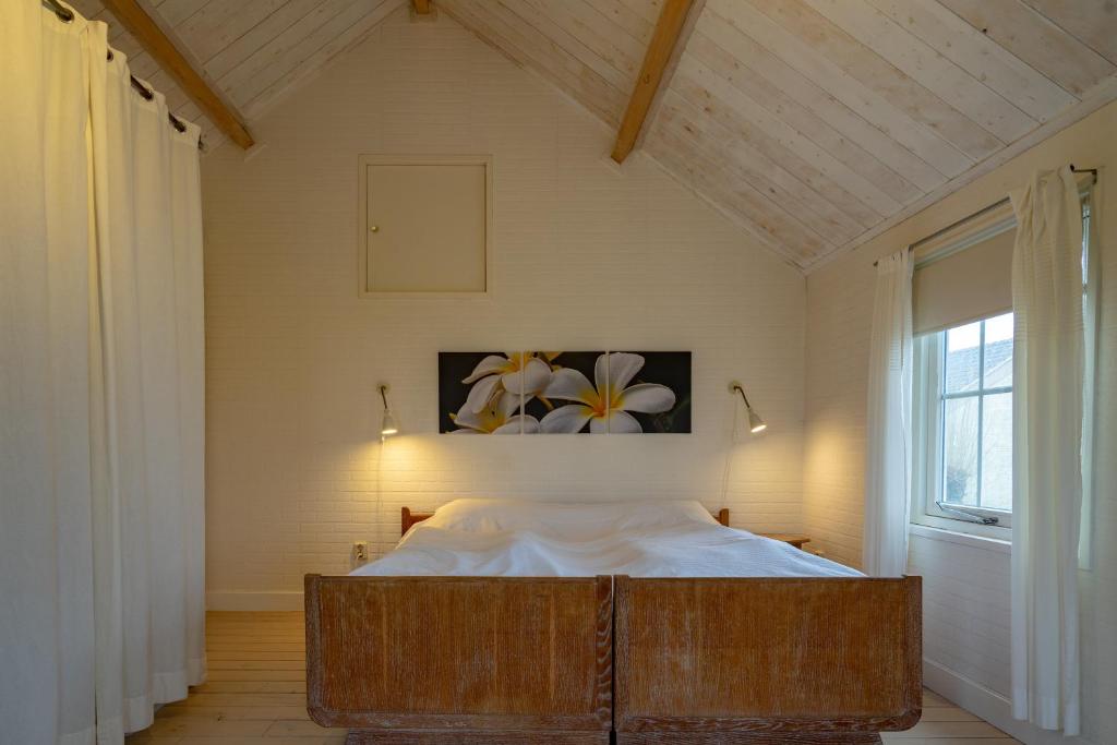 een slaapkamer met een bed in een kamer met een raam bij Landzicht Vakantiehuis aan de Fluessen in Elahuizen