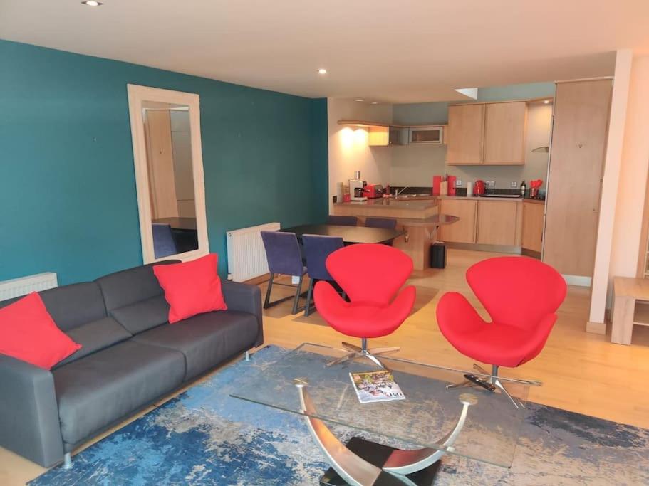 uma sala de estar com um sofá e duas cadeiras vermelhas em West End & EICC with Parking em Edinburgo