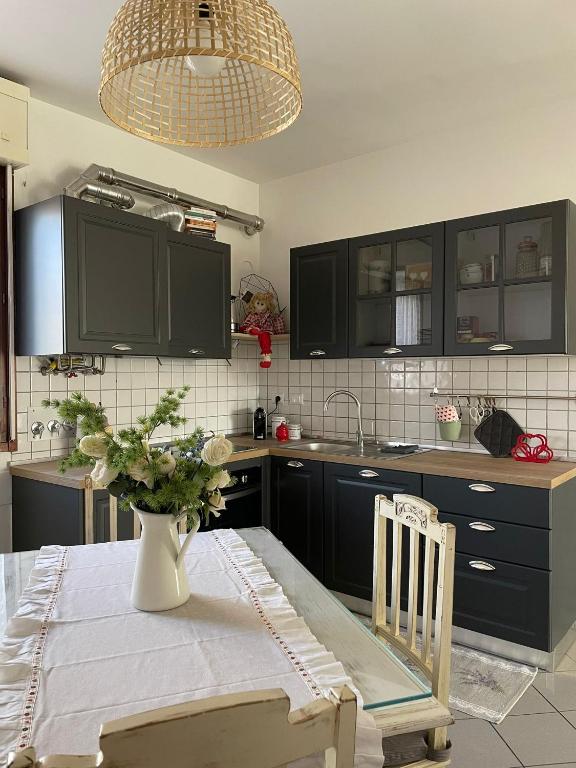 Hotel Apartment "La Balotta", a kitchen with a table with a vase of flowers on it at Apartment "La Balotta" in Bologna