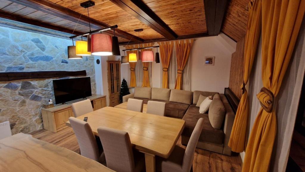 een eetkamer en een woonkamer met een tafel en een bank bij Ski House in Kopaonik