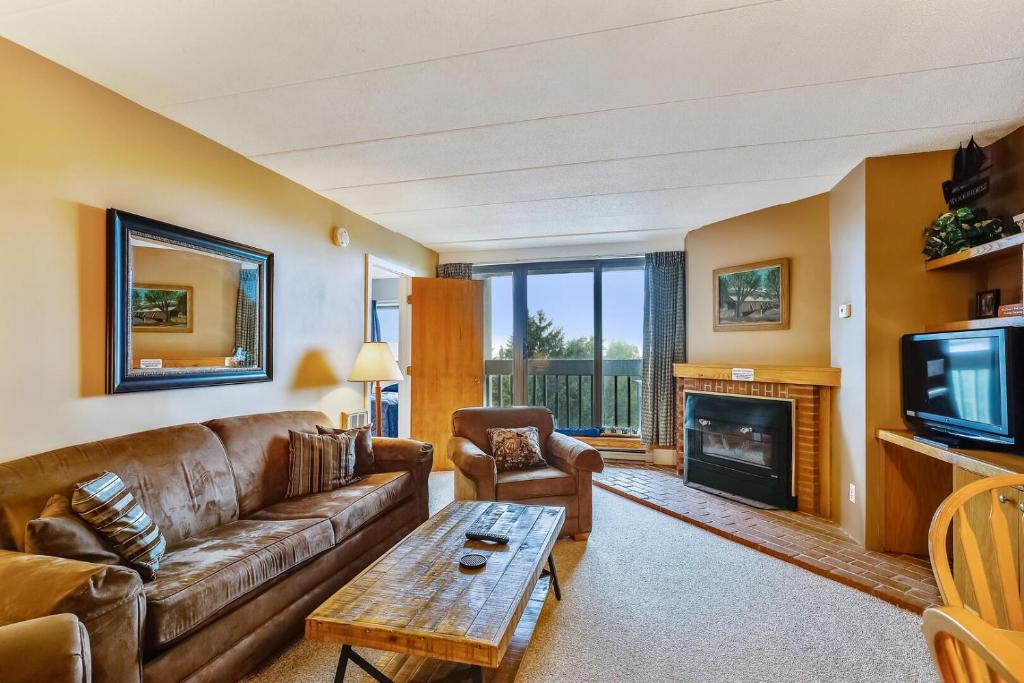 a living room with a couch and a fireplace at Pinnacle C10 in Killington