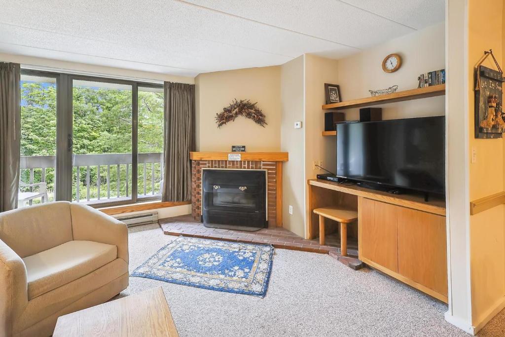 a living room with a television and a fireplace at Pinnacle E07 in Killington