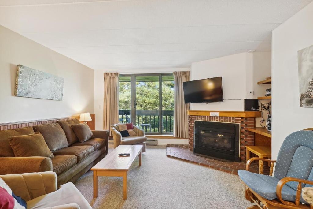 a living room with a couch and a fireplace at Pinnacle E22 in Killington