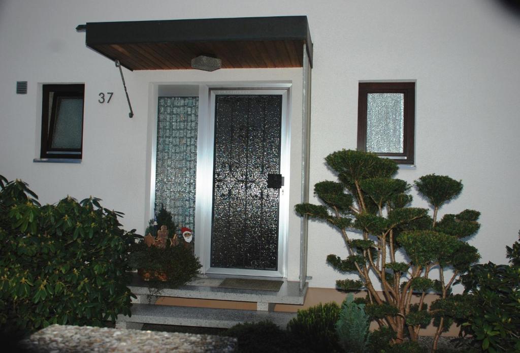 a front door of a house with trees and plants at Gästezimmer Anita in Schwabach
