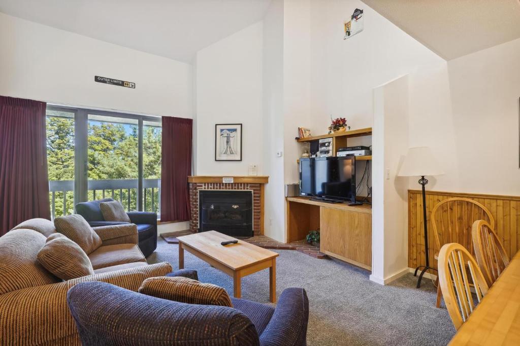 a living room with a couch and a fireplace at Pinnacle E25 in Killington