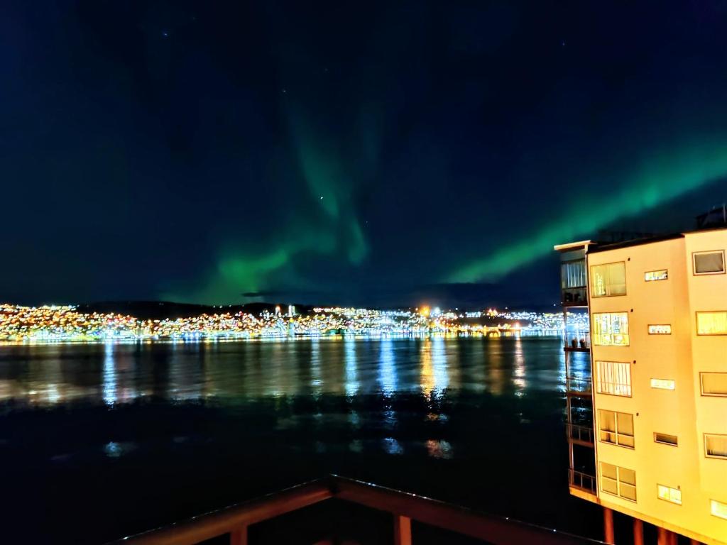 an image of a city with the aurora in the sky at Top floor apartment with a magic view in Tromsø