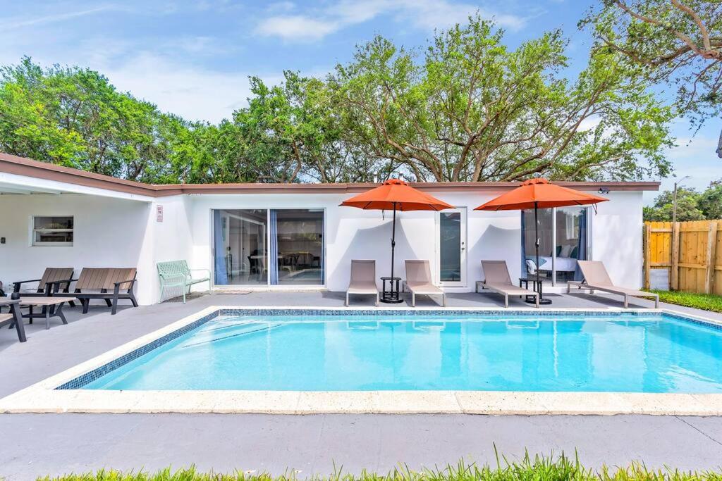 een zwembad met twee parasols en een huis bij Modern Getaway 4BRs House with Pool and Game Room in Hollywood