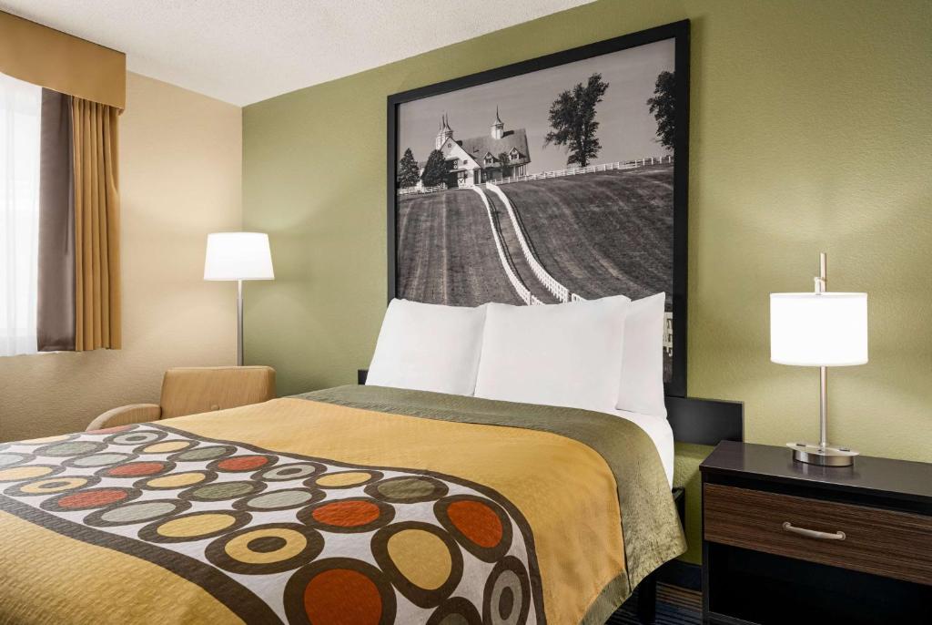a hotel room with a bed and a picture on the wall at Super 8 by Wyndham Maysville KY in Maysville