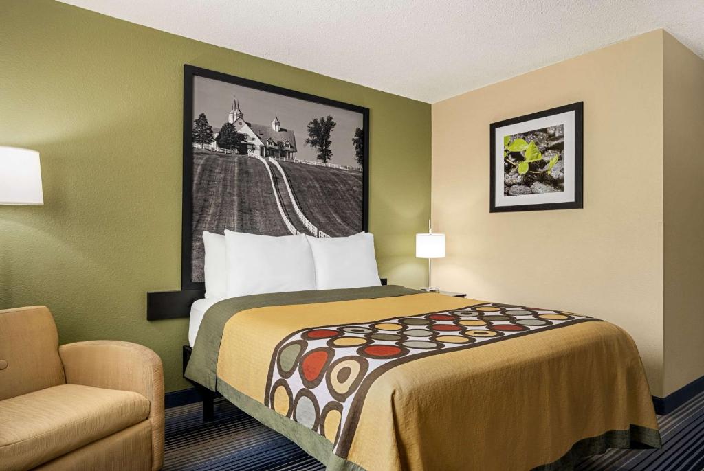 a hotel room with a bed and a chair at Super 8 by Wyndham Maysville KY in Maysville