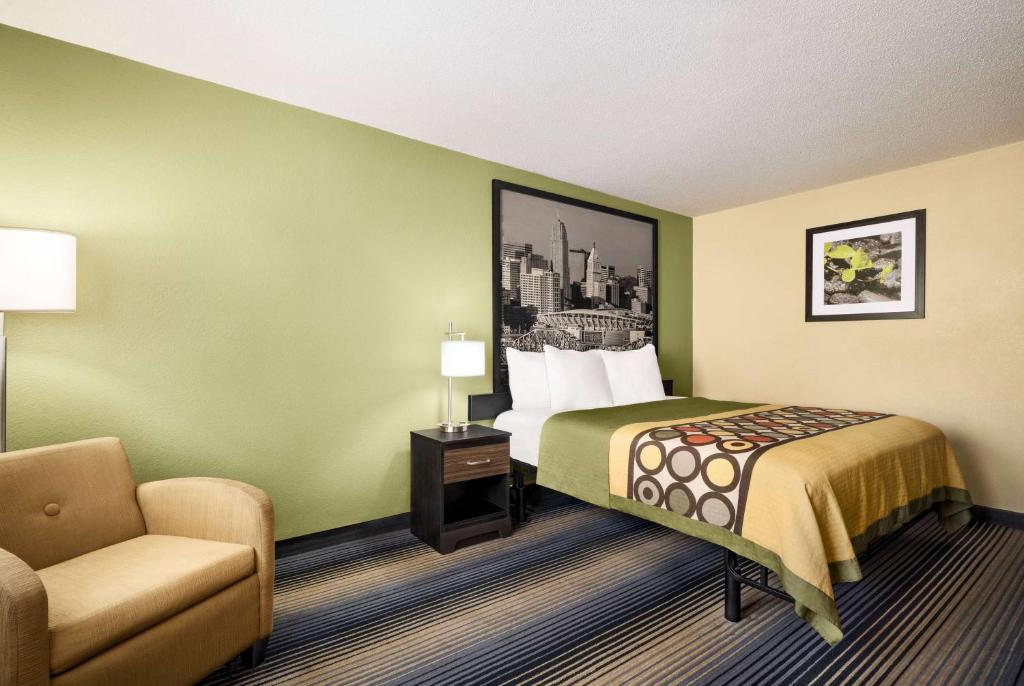 a hotel room with a bed and a chair at Super 8 by Wyndham Maysville KY in Maysville