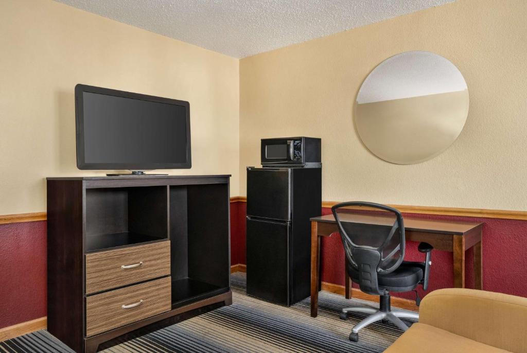 a room with a desk and a chair and a television at Super 8 by Wyndham Maysville KY in Maysville