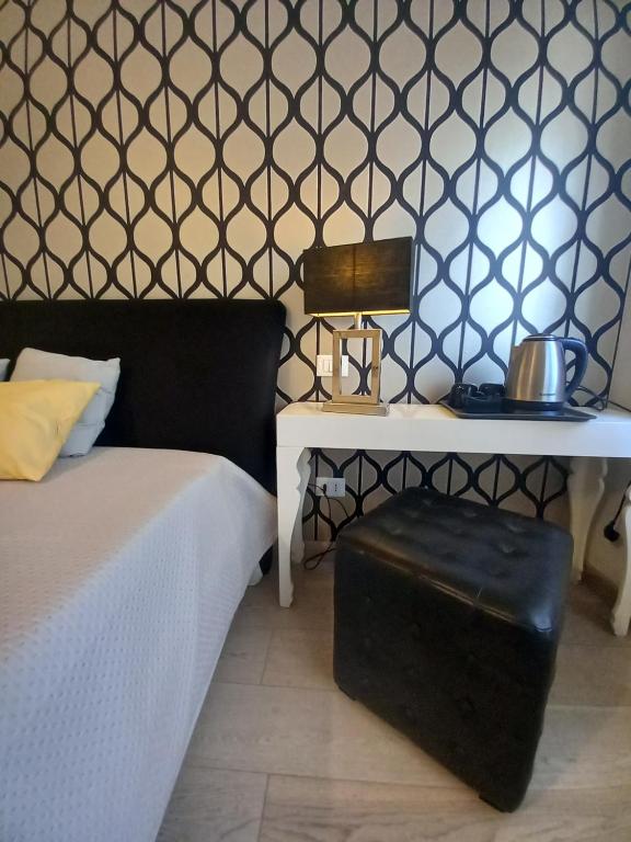 um quarto com uma cama e uma mesa com um candeeiro em Quartopiano Guesthouse em Roma