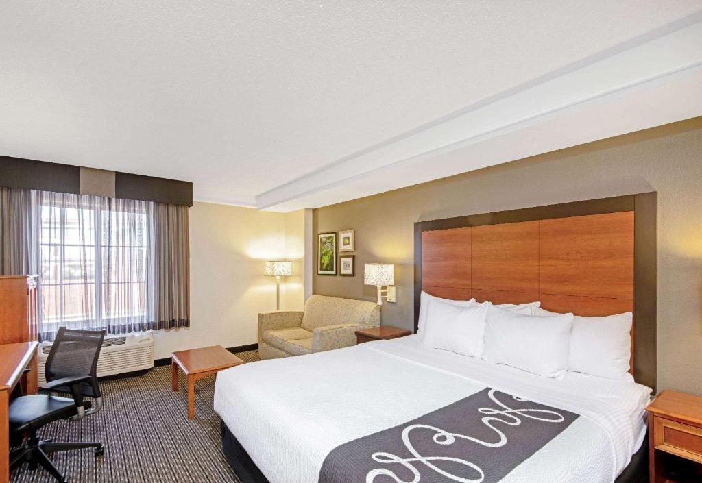a hotel room with a bed and a desk at La Quinta by Wyndham San Antonio Airport in San Antonio