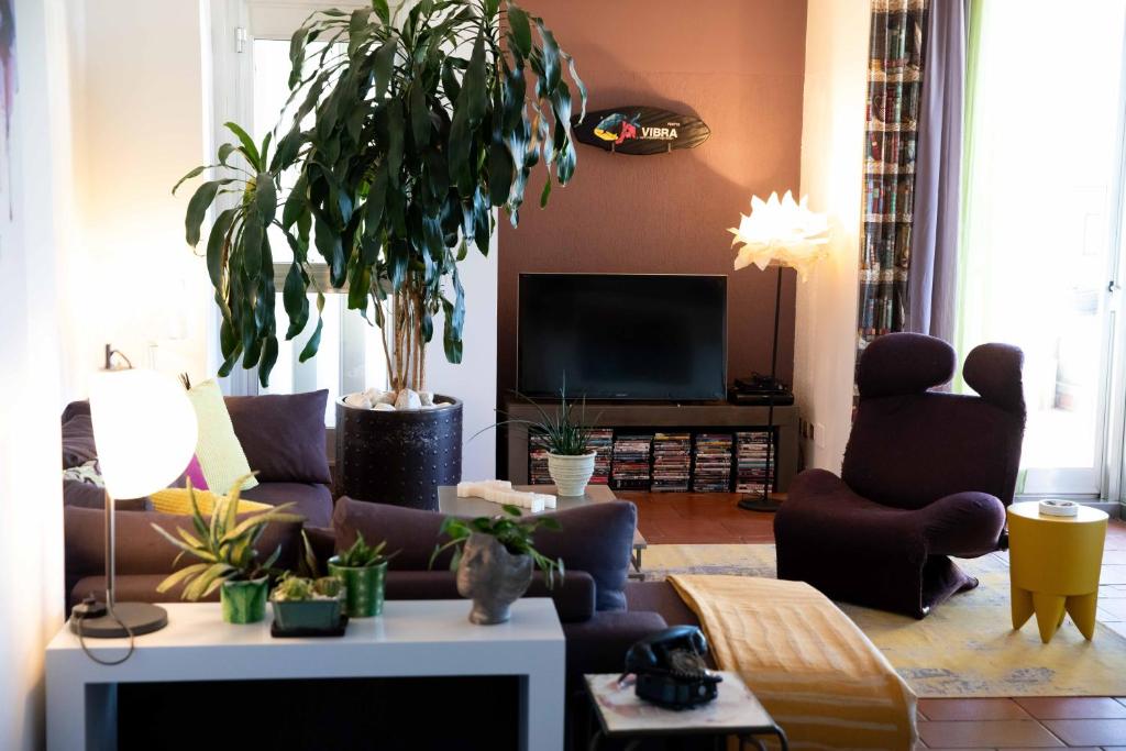 een woonkamer met een bank en een potplant bij Sound of Colors - Art Design Apartment in Desenzano del Garda