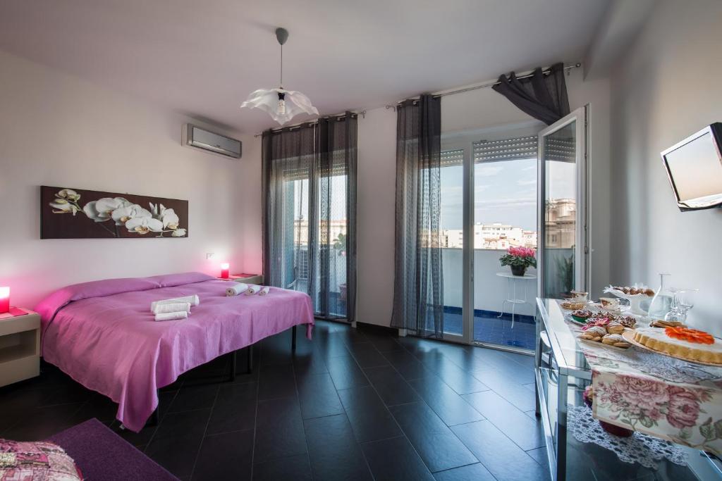 Un dormitorio con una cama rosa y una mesa con comida en Bed and Breakfast Palermo Centro, en Palermo