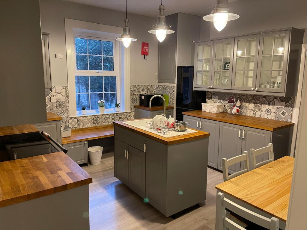 a large kitchen with gray cabinets and a kitchen island at Spacious 4-bed Holiday Home in the heart of Maidstone in Maidstone