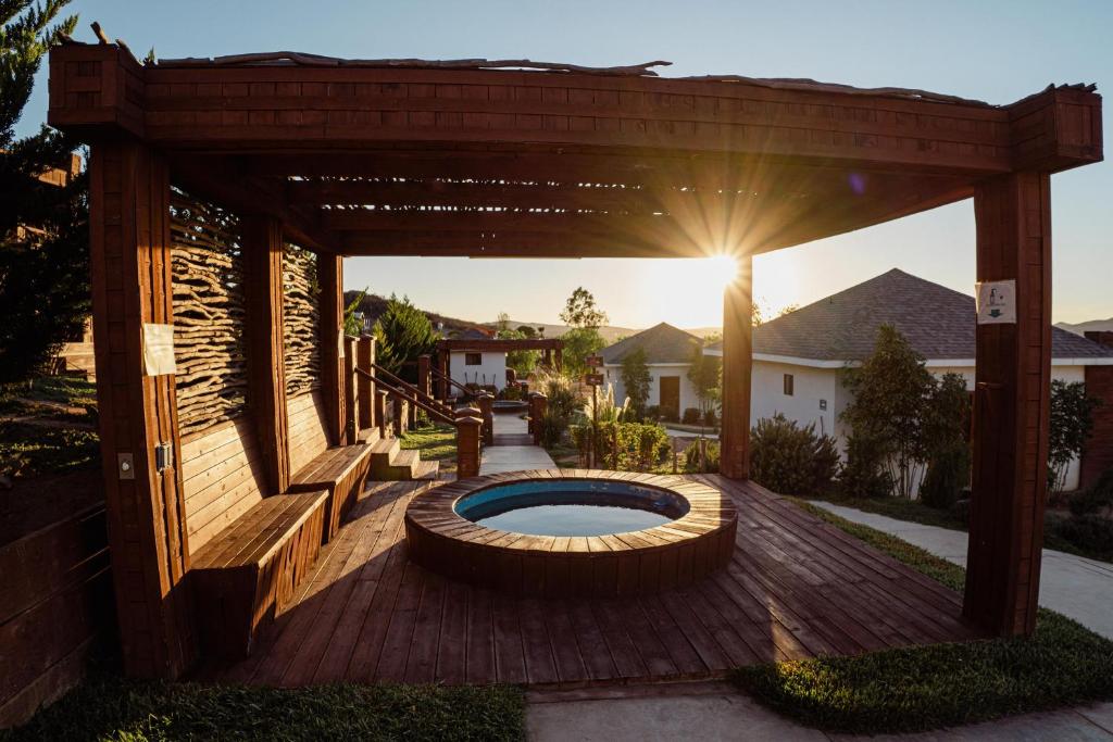a backyard with a wooden pergola and a swimming pool at Entrevalle Hotel Boutique in Valle de Guadalupe