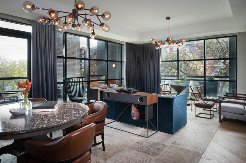 a living room with a table and chairs and windows at Hotel Van Zandt in Austin