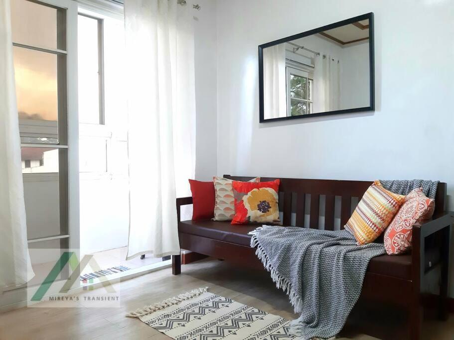 a living room with a couch and a mirror at Mireya's 1BR condo at Zone Vill - Burnham Park in Baguio