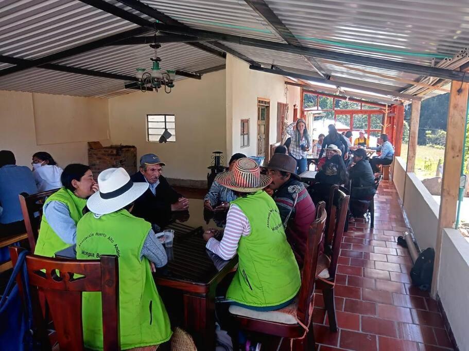 un grupo de personas sentadas en una mesa en un restaurante en Rancho Santa Inés Completo, en Monguí