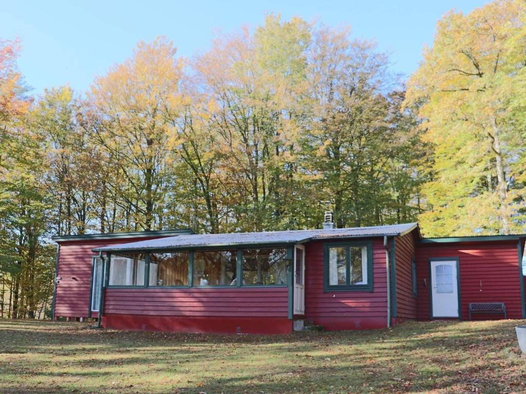 a red house in a field with trees at 4 person holiday home in SKÅNES-FAGERHULT-By Traum in Slättsjö