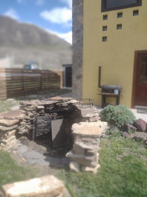 a stone fireplace in a yard next to a building at Paso del Cuadrado in El Chalten
