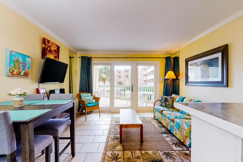 a living room with a couch and a table at Victorian Condos Barefoot Beach Haven in Galveston