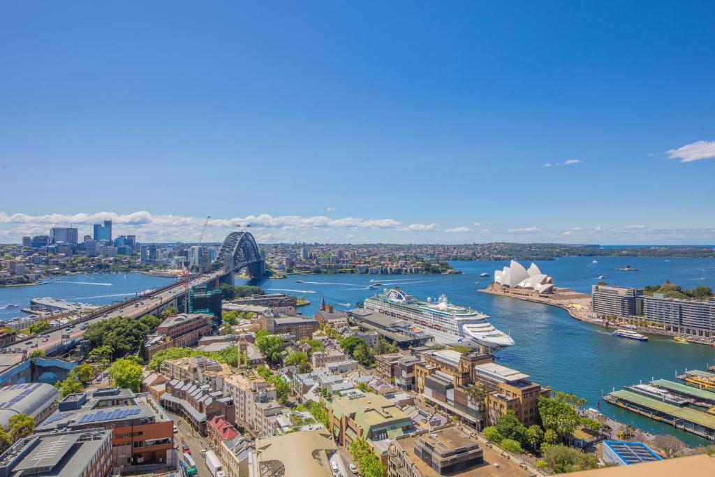 an aerial view of a city with a river and a harbor at Comfy One Bedroom Apartment In Heart of The Rocks in Sydney