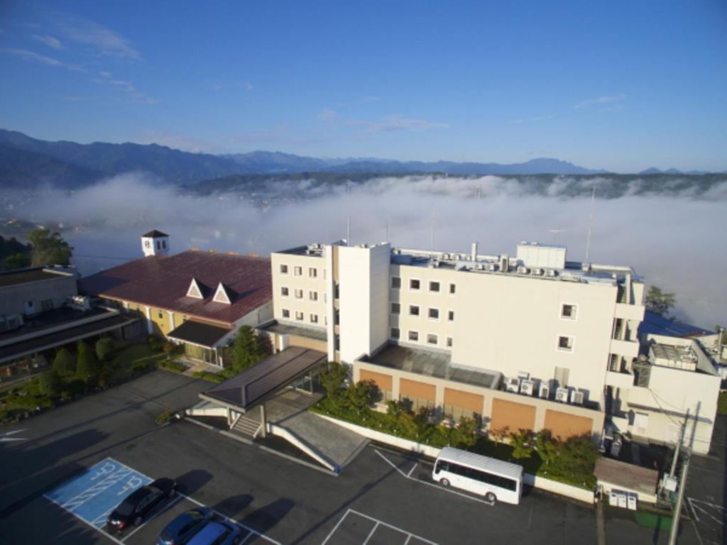 einen Blick auf ein Gebäude mit Nebel im Hintergrund in der Unterkunft Natural Farm City Noen Hotel in Chichibu