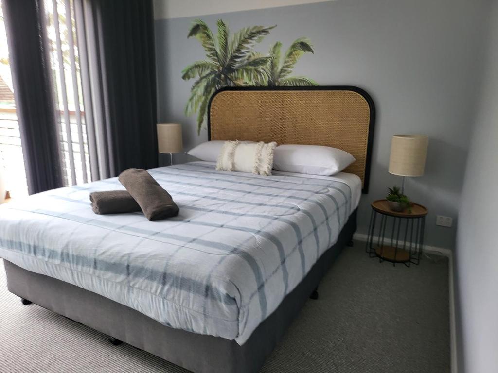 een slaapkamer met een groot bed met 2 kussens erop bij Emina's Granny Flat in Woollamia