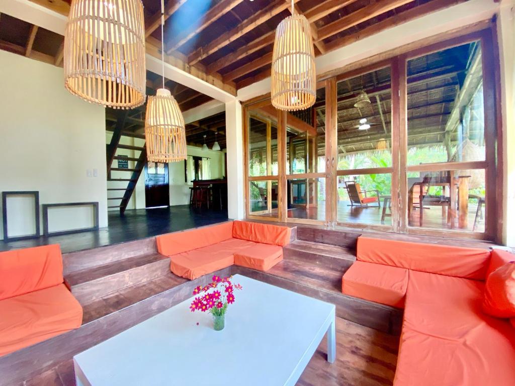 sala de estar con sofás naranjas y mesa en Emerald House Village en General Luna