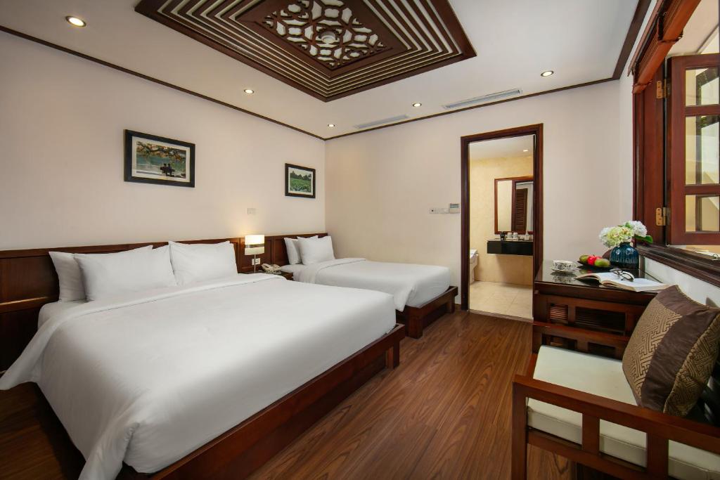 Postel nebo postele na pokoji v ubytování Hanoi Nostalgia Hotel & Spa