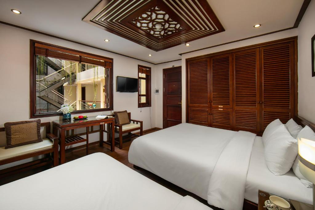 Postel nebo postele na pokoji v ubytování Hanoi Nostalgia Hotel & Spa