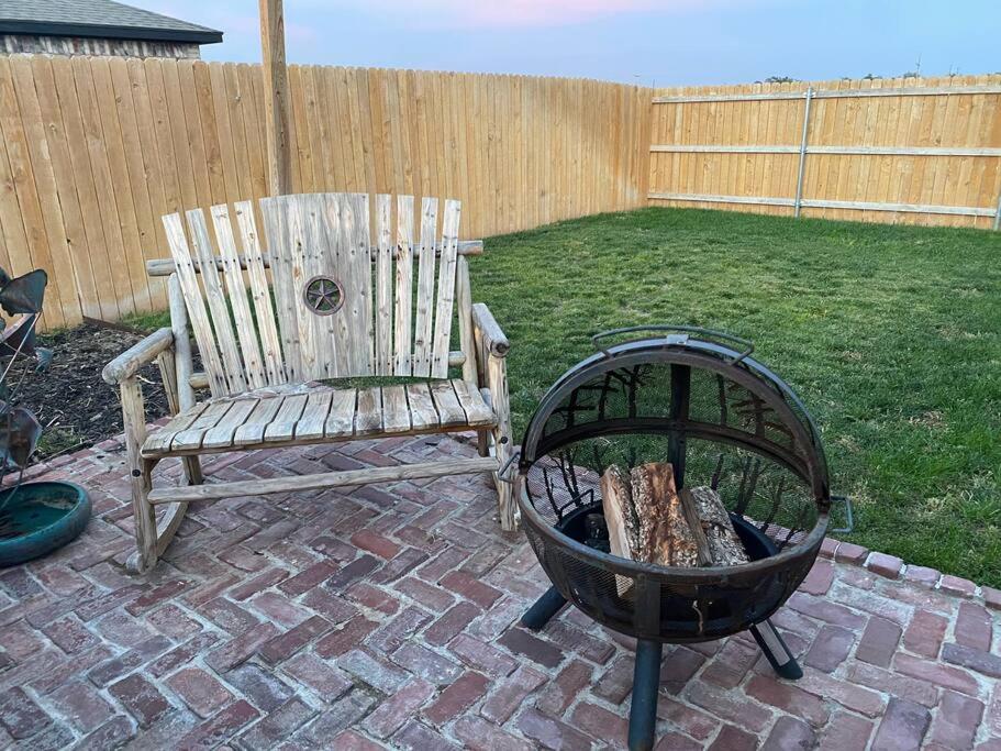 a wooden chair and a fire pit in a backyard at 10 min airport 15 min PD Canyon in Amarillo