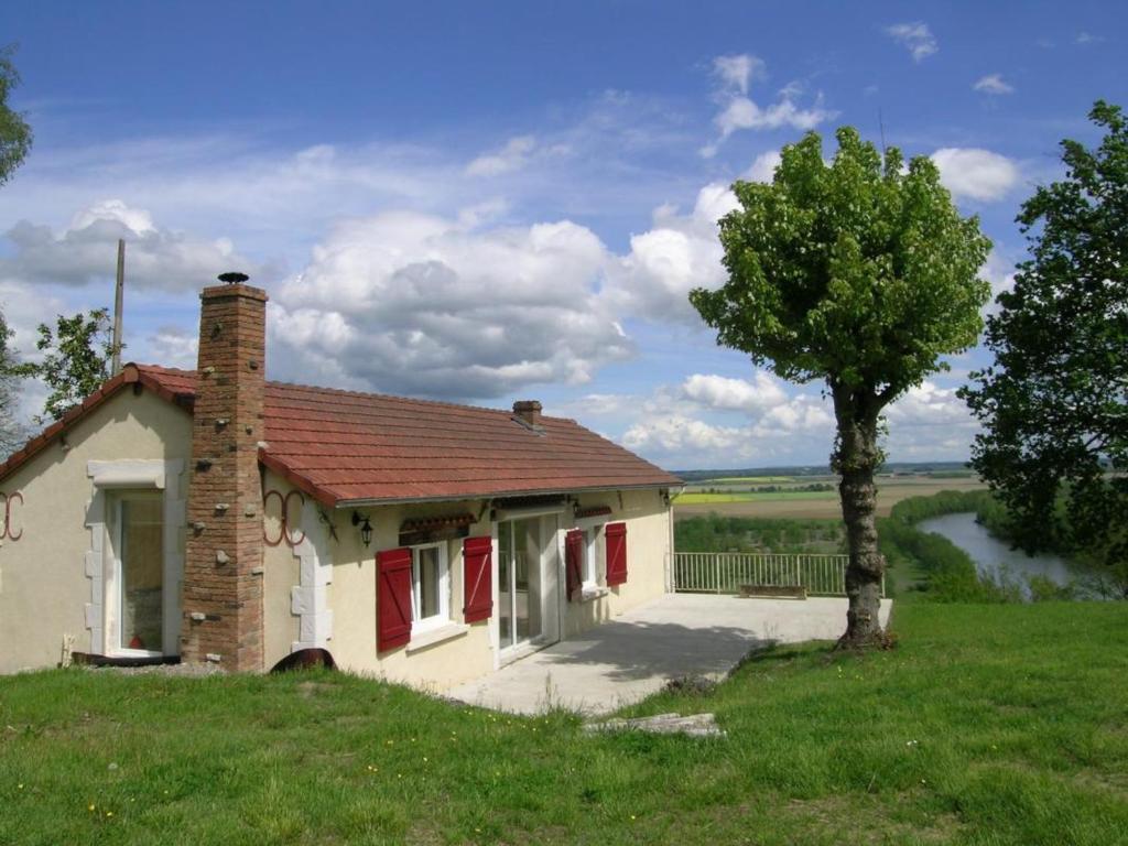 una pequeña casa en una colina con un árbol en Gîte Monétay-sur-Allier, 3 pièces, 4 personnes - FR-1-489-110 en Monétay-sur-Allier