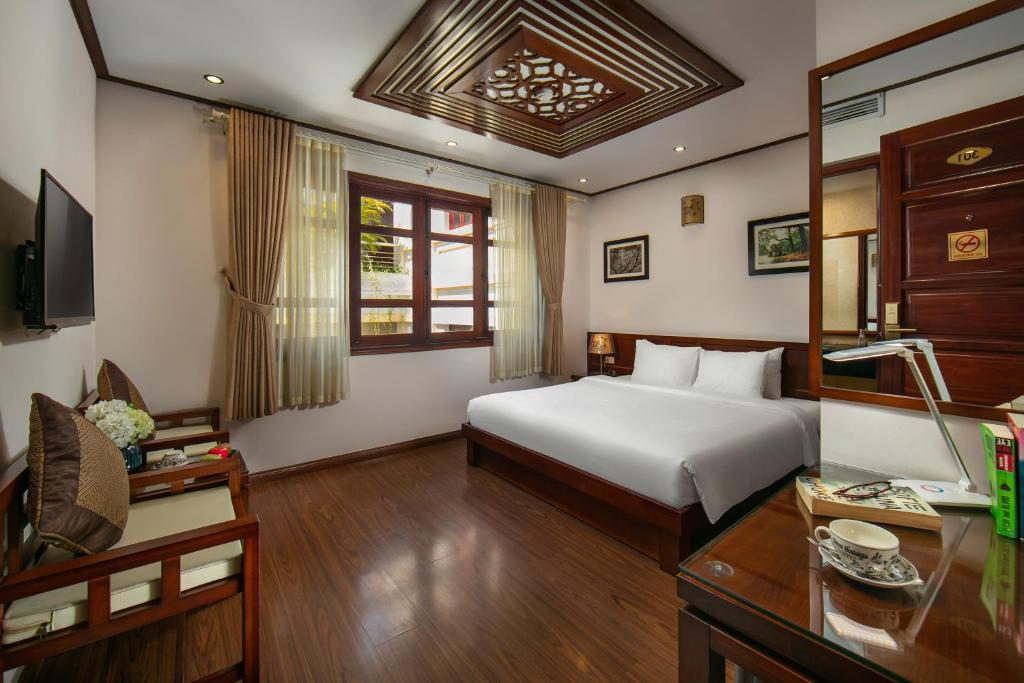 Postel nebo postele na pokoji v ubytování Hanoi Nostalgia Hotel & Spa