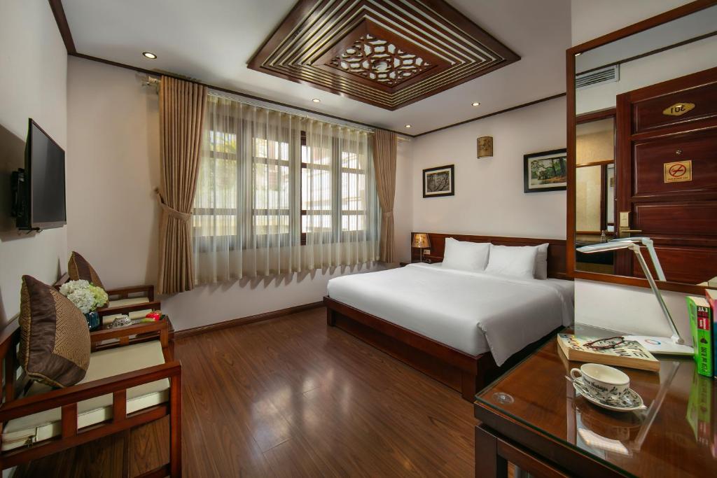 Postel nebo postele na pokoji v ubytování Hanoi Nostalgia Hotel & Spa