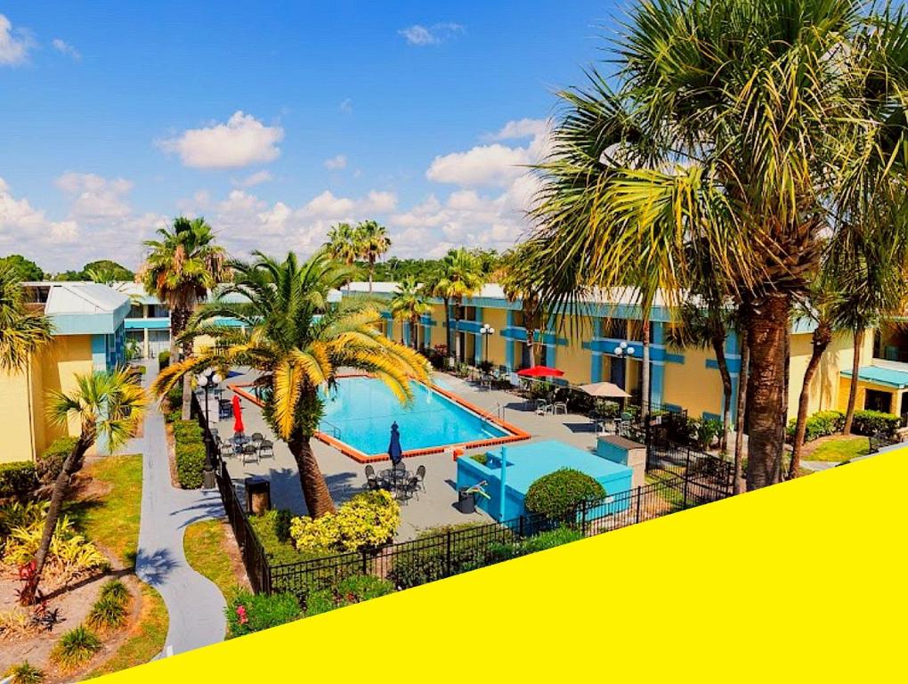 Blick auf ein Resort mit Pool und Palmen in der Unterkunft Bposhtels Orlando Florida Mall in Orlando