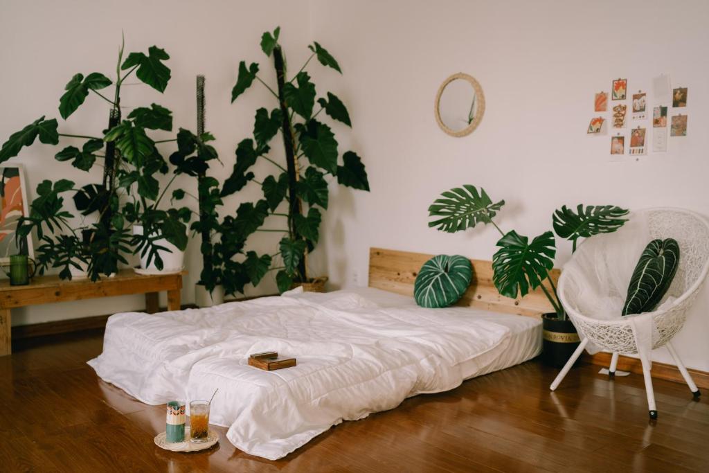 - une chambre avec un lit, une chaise et des plantes dans l'établissement LáVuTa Home, à Vung Tau