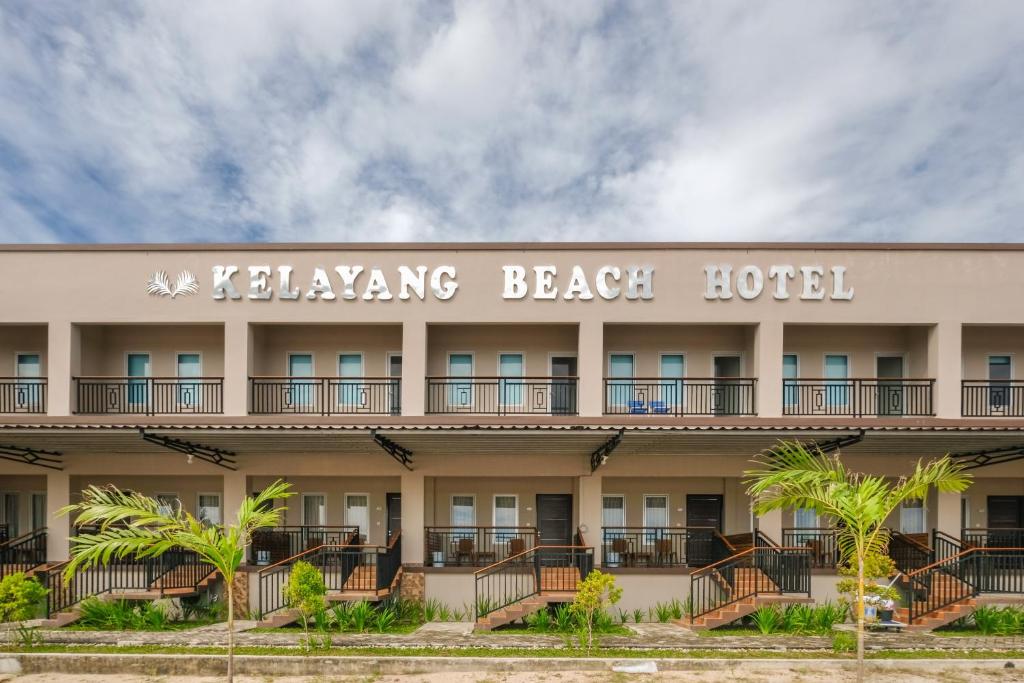 a hotel with a sign for the bellingham beach hotel at Kelayang Beach Hotel in Tanjungbinga