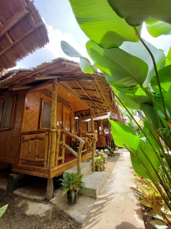 une maison en bois avec une terrasse couverte et quelques plantes dans l'établissement Jake and Zyra Place, à San Vicente