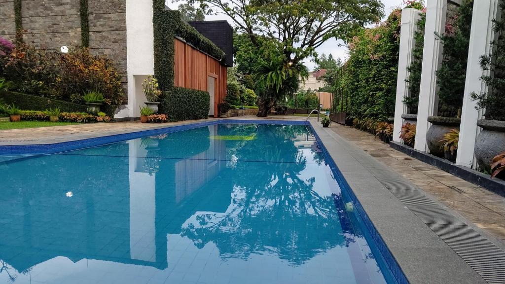 a swimming pool with blue water in a yard at Samami Garden in Bandung