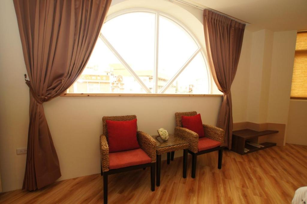 two chairs and a table in front of a window at Taitung Venice B&B in Taitung City
