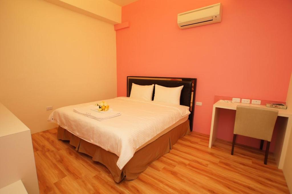 a small bedroom with a bed and a desk at Taitung Venice B&amp;B in Taitung City