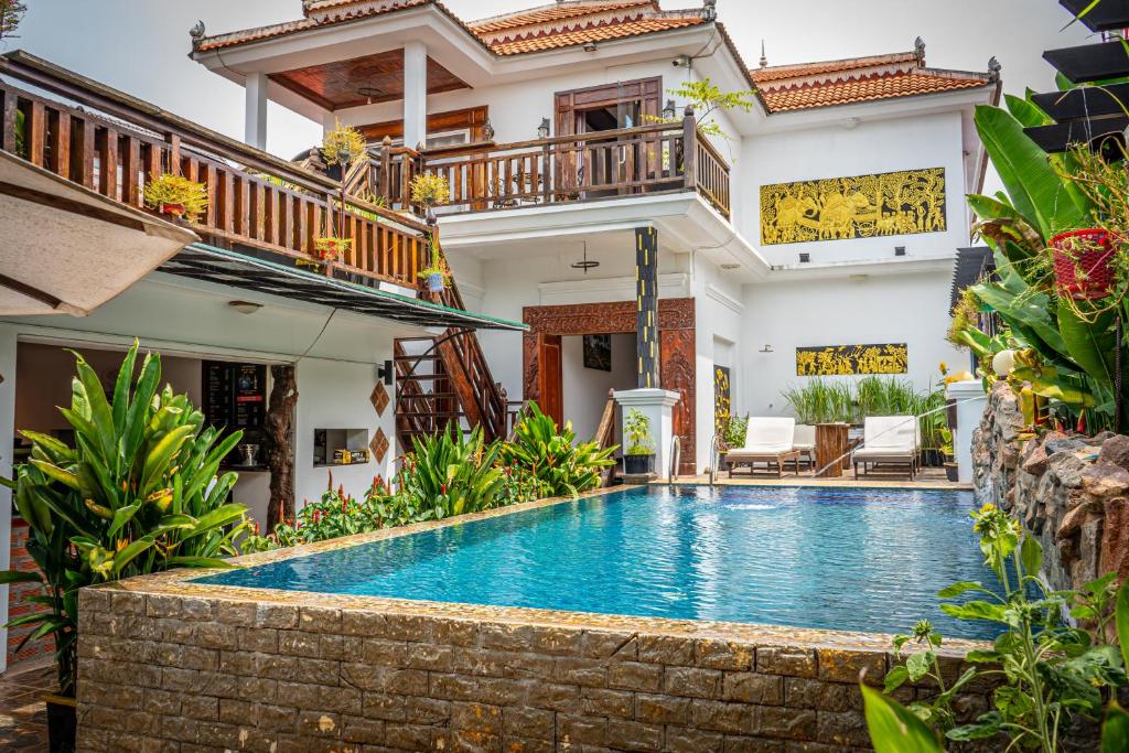 a swimming pool in front of a house at Antonios Villa Hotel in Siem Reap