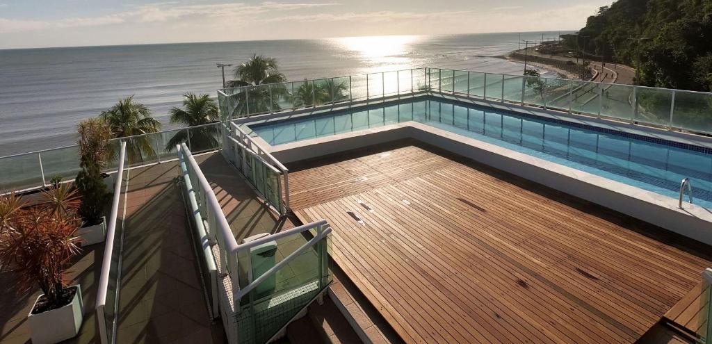 a swimming pool on top of a building next to the ocean at Blue Sunset Prime com vista para mar in João Pessoa