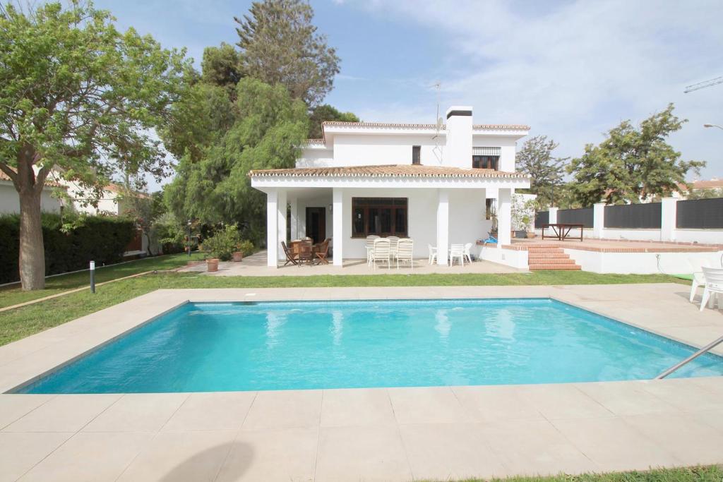 uma villa com piscina em frente a uma casa em Del Parque Flats Villa Sauce em Chilches